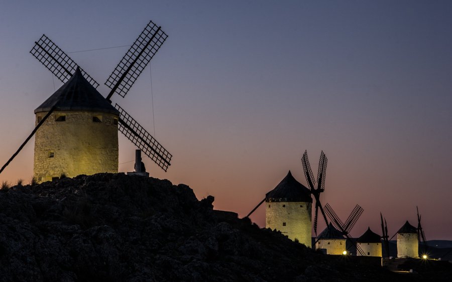 Fivewindmills in Consuegra during the night, on top of a hill with some ligting